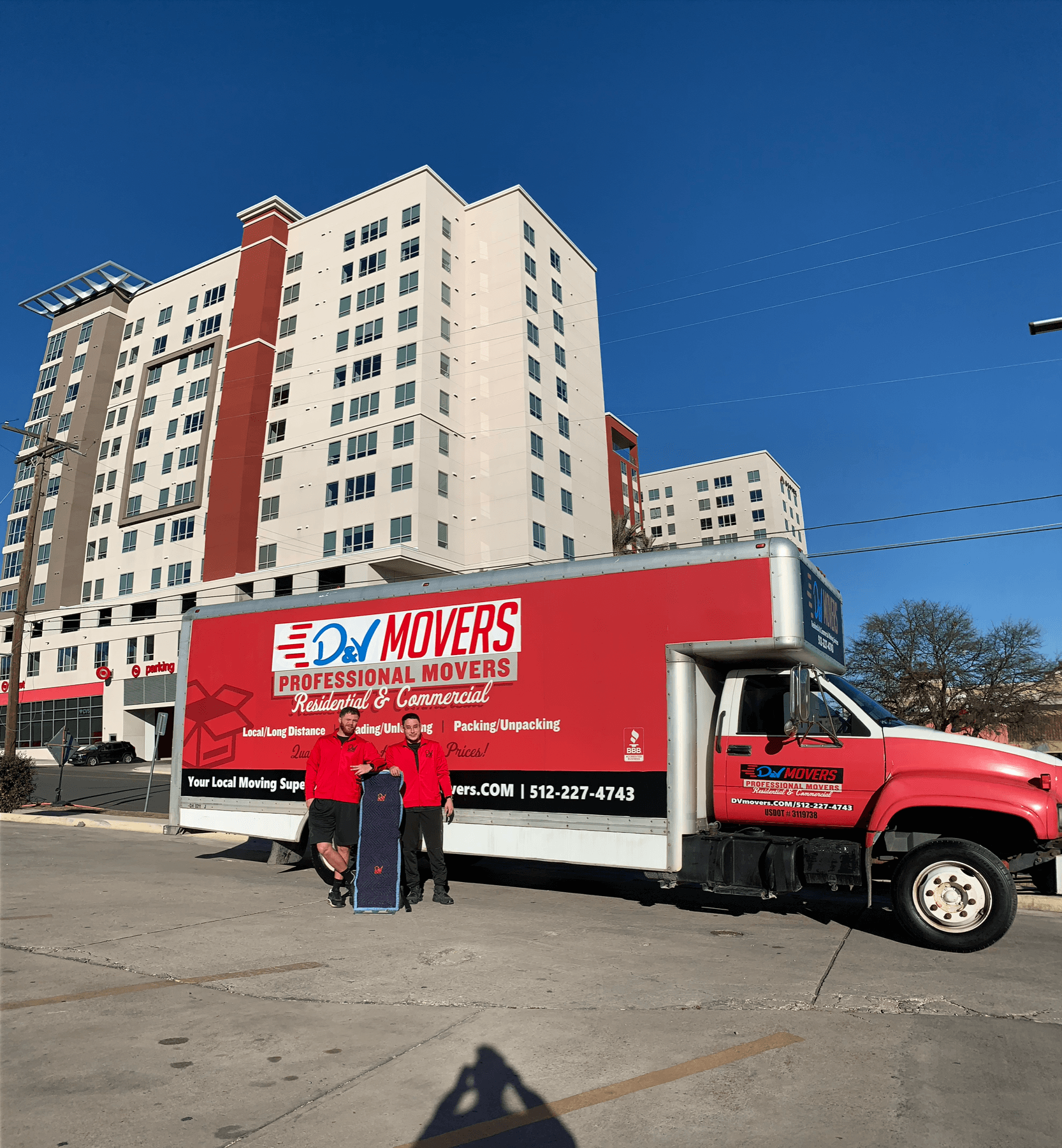 Dylan and Vinny, co-founders of D&V Movers, in front of a company truck