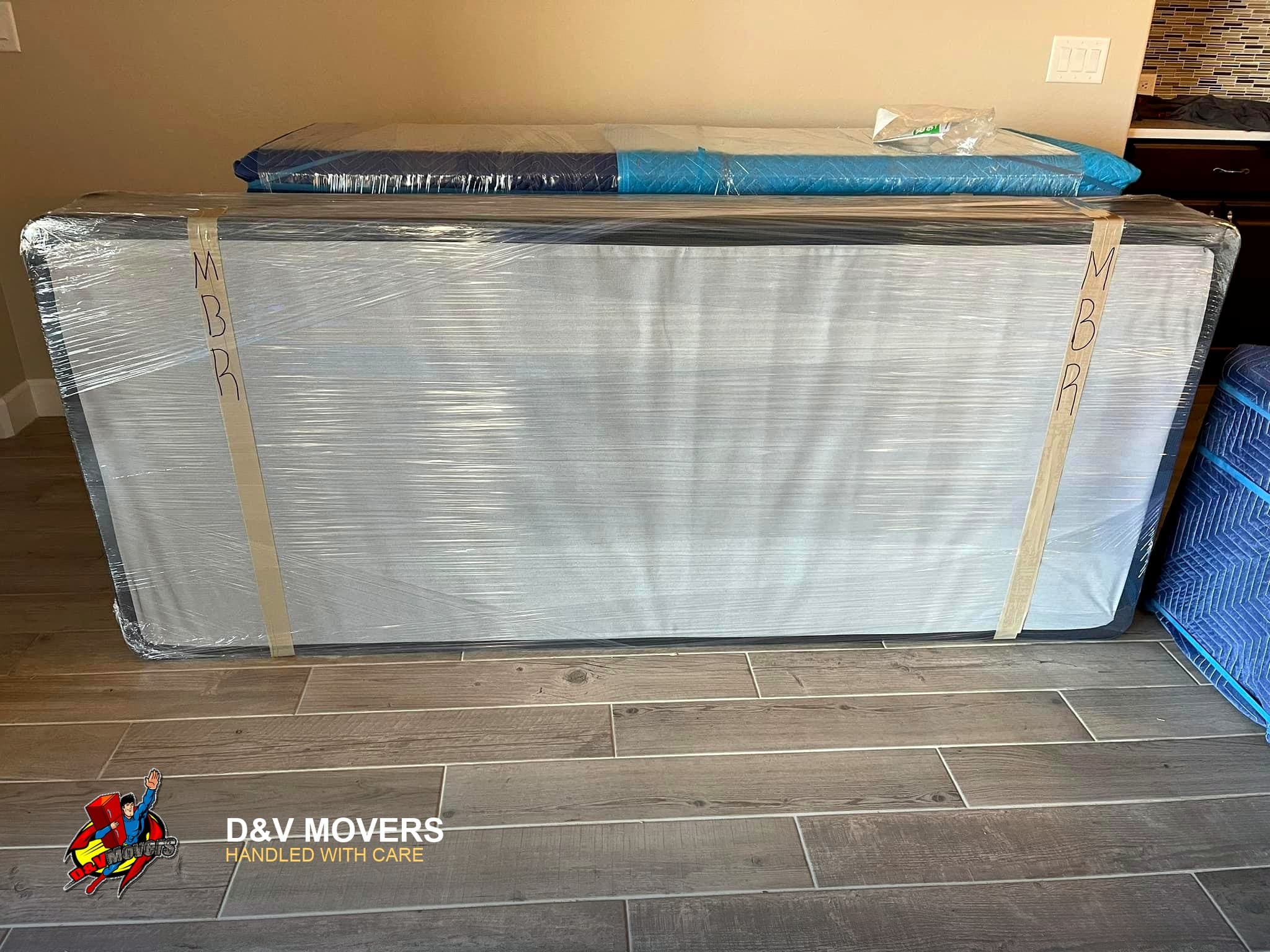 A mattress and box spring shrink-wrapped and labeled for a move